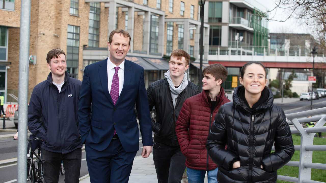 Jim O'Callaghan walking among a group of young people alongside Dublin canal.